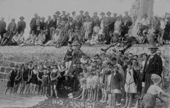 Biddy-the-Tub-Man-looking-a-bit-lost-amongst-his-crowds-of-supporters-on-the-beach.-1937.